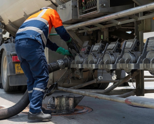 Driver hooking up hose to tank truck